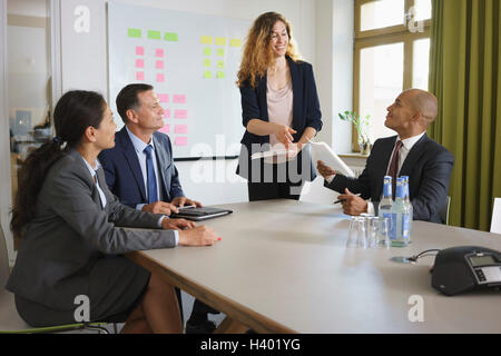 Imprenditrice dando la presentazione ai colleghi in riunione a un tavolo per conferenza Foto Stock