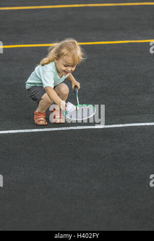 Felice ragazza che gioca con badminton racchetta e volano sul parco giochi Foto Stock