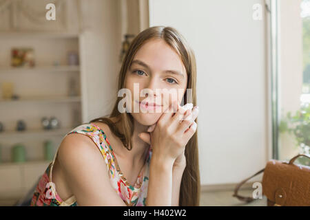 Ritratto di sorridente bella donna appoggiata sulla tavola da una finestra Foto Stock