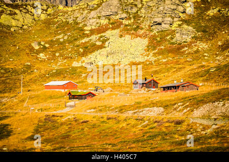 Perso red cottages in ruvido paesaggio norvegese durante l'autunno Foto Stock