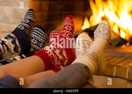 Famiglia in calze vicino al caminetto in inverno o tempo di Natale Foto Stock