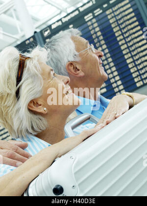 Aeroporto hall, information board, coppia Senior, bagagli, sorriso, informare pagina ritratto, aeroporto, giovane, cittadini anziani, passeggeri passeggeri delle compagnie aeree, partenariato, coppie sposate, migliore età, turisti, informazioni, pannello di indicatore, felice, allegria, co Foto Stock