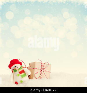 Regalo di natale Scatola e pupazzo giocattolo in neve con sfondo per copiare lo spazio. Dai toni rétro Foto Stock