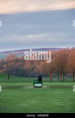 Uomo alla guida di un giro-sul rullo, preparare il paletto di un villaggio campo da cricket - Bolton Abbey Cricket Club, Yorkshire Dales. Foto Stock