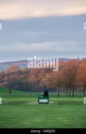 Uomo alla guida di un giro-sul rullo, preparare il paletto di un villaggio campo da cricket - Bolton Abbey Cricket Club, Yorkshire Dales. Foto Stock