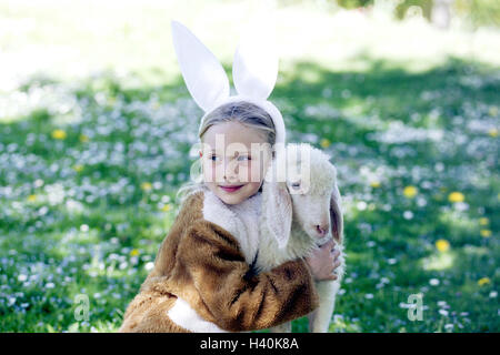 Prato, ragazza, lepre è costume, agnello, abbracciare, ritratto, pasqua, festa di Pasqua, bambino, infantile, infanzia, rivestimento, pannelli, costume, lepre le orecchie, agnello pasquale, Nestle, animale-amare, animale-amare, animale amicizia, ritratti di bambini Foto Stock