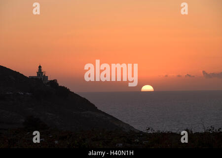 Tramonto al faro sulla punta occidentale dell'isola di Santorini, Grecia. Foto Stock