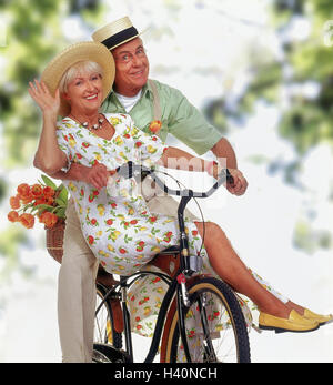 Parco, coppia Senior, bicicletta, andare, wave insieme, donna, le estati Senior, uomo, donna, vecchio, a cavallo di una bicicletta, cittadini anziani, giovane, cappelli di paglia, felice, divertimento e tempo libero, sorriso, gioia, estate, studio, Foto Stock