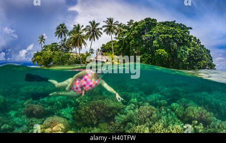 Immagine sdoppiata colpo di isola tropicale con femmina snorkel diver esplorare Coral reef Foto Stock