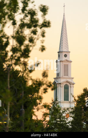 Il bianco campanile della prima chiesa battista Snellville si eleva alto nella luce calda del crepuscolo in Snellville, Georgia, Stati Uniti d'America. Foto Stock