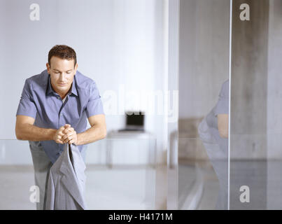 Edifici per uffici, hall, lavoratore di ufficio, vetro balaustra, stand, riposo, premuroso, business, le imprese locali, hall, a piedi, vetro ringhiera, ringhiera, balaustra, vetro, uomo giovane, pausa, pausa di lavoro, di riposo e di recuperare, attendere pazientemente pensare, il periodo di attesa, c Foto Stock