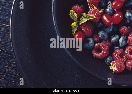 Chiusura del contenitore pieno con freschi frutti di bosco organico Foto Stock