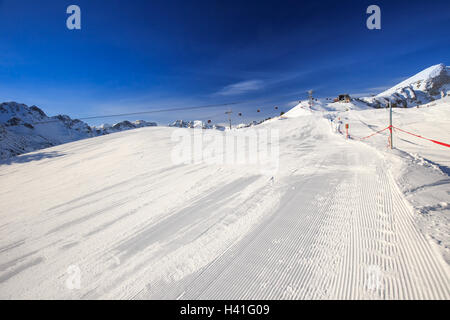 Vista di piste da sci con il modello di velluto a coste e ski seggiovie sulla sommità del Fellhorn Ski Resort, Alpi Bavaresi, Oberstdorf, Ge Foto Stock