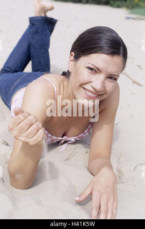 Donna, giacciono i giovani, per il tempo libero, spiaggia, sabbia, play, 20-30 anni, 23 anni, jeans, top visualizza fotocamera, ridere, amichevole, corso, naturalezza, equilibrio, soddisfazione, ricreazione, riposo, take it easy, di riposo e di godere, piacevole sensazione, estati, tempo libero, vacanze Foto Stock