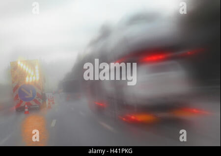 Autostrada, uomini al lavoro, traffico, pioggia, sfumare il traffico autostradale, uomini al lavoro gamma, traffico, street passaggio di parzializzazione, design e lay-out di una strada, segno di traffico, freccia, transporter, LKW's, automobili, luci posteriori, drive, il pericolo e la situazione di pericolo, velocità, pioggia Foto Stock