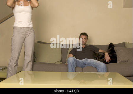 Spazio di vita, l'uomo, divano, si siede, donna, sorge, dettaglio disarmonia, serie, partenariato, relazione, controversia, umore negativamente, interessi deceduto, noia, insoddisfazione, purtroppo, relazione crisi, Lifestyle, interno, Foto Stock