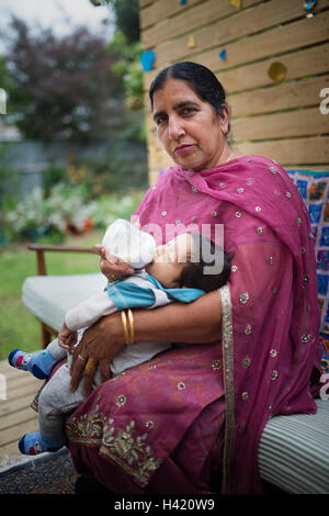 Nonna indiano biberon al nipote Foto Stock