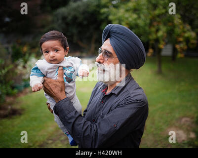 Nonno indiano holding baby nipote Foto Stock