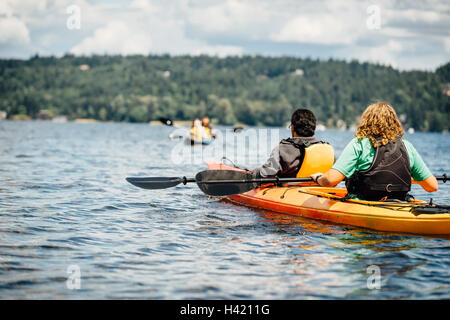 L uomo e la donna le piastre di contenimento in kayak Foto Stock