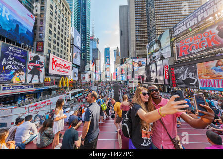 I turisti tenendo selfies in Times Square a New York City e New York. Foto Stock