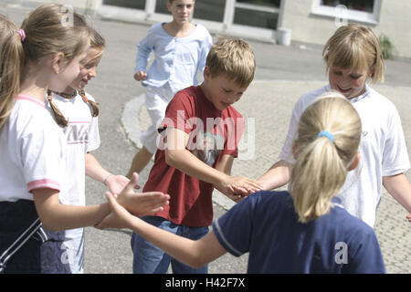 Parco giochi, studentesse, stand, giocare a cerchio, mani, touch, solo editorialmente scuola, pausa, pausa di corte, bambini, scolari, ragazze, boy, scuola bambini, scuola di colleghi e compagni di classe i compagni di scuola, amici, di amicizia, di riposo e di divertimento, interruttore di divertimenti Foto Stock