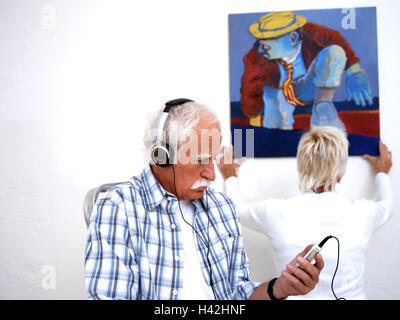 Lavori di restauro, senior, auricolare, ascoltare musica, sfondo, donna, immagine, riagganciare, 60-70 anni, giovane, partenariato, uomo, ricreazione, di riposo e di relax, musica, lettore iPod, concentrazione, apertura mentale, progresso, tecnologia moderna, raddrizzare attivamente, montare Foto Stock