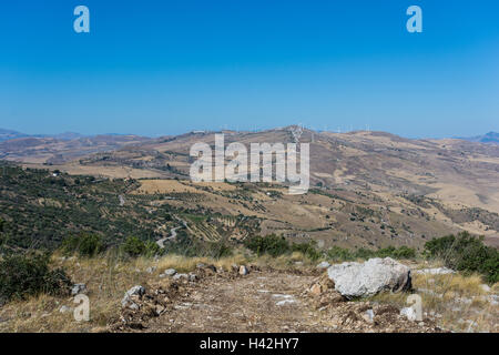 Paesaggi della Sicilia centrale in estate. Con la tipica siciliana di colline e ulivi, con una strada che si snoda attraverso la moun Foto Stock