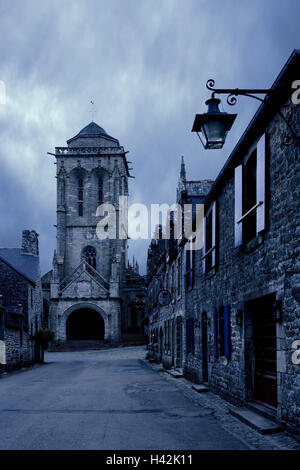 Francia, Bretagna, Finisterre, Locronan, Dvillage road, facciate di case, chiesa, crepuscolo, Foto Stock