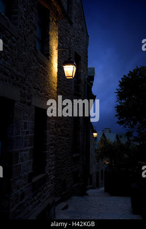Francia, Normandia, Manche, Mont Saint-Michel, centro storico vicolo, lanterne, atmosfera serale, Foto Stock