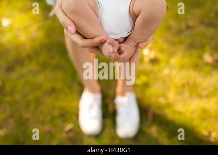 Madre tenendo il suo bambino in mani Foto Stock