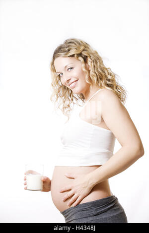 Donna, giovane, bionda, in gravidanza, toccando, pancia, vista laterale, latte vetro, azienda, Foto Stock