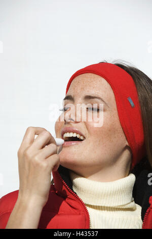 Donna, giovane, fascia, giacca rossa, lip care, ritratto, inverno, Foto Stock