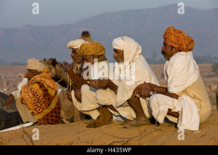 India Rajasthan, Pushkar, pellegrino la festa, uomini, sedersi, vista laterale, nessun modello di rilascio, Foto Stock