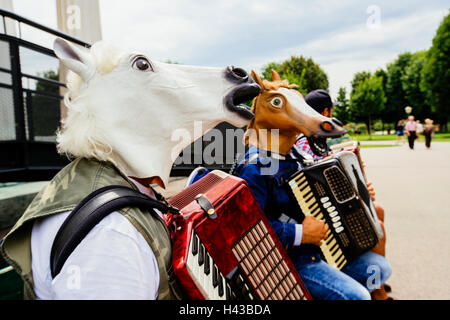 I fisarmonicisti che indossano maschere di cavallo Foto Stock