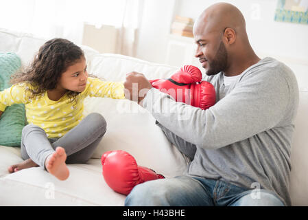 Padre aiutando la figlia con i guantoni Foto Stock