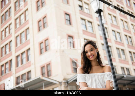 Sorridente razza mista donna in posa nella città Foto Stock