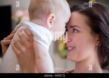 Madre caucasica toccare fronte con baby figlio Foto Stock