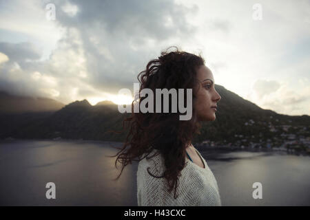 Vento capelli di razza mista donna vicino al lago Foto Stock