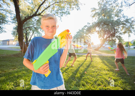 Ragazzo caucasico posa con squirt pistole Foto Stock