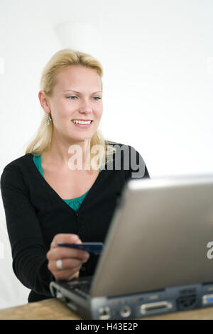 Donna, sorriso giovani, laptop, carta di credito, visualizzazione monitor Foto Stock