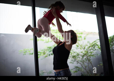 Giocoso ispanico madre figlia di sollevamento Foto Stock