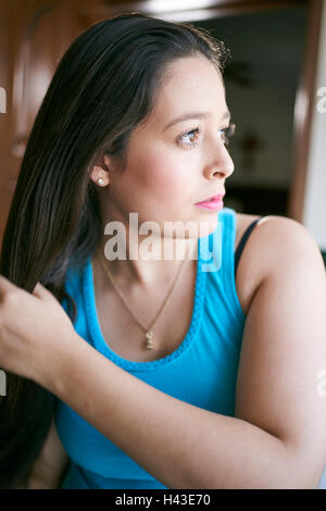 Donna ispanica spazzolare i capelli Foto Stock