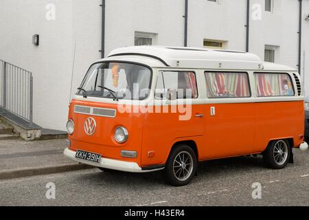 Orange Volkswagen camper van in Scozia, Regno Unito. Foto Stock