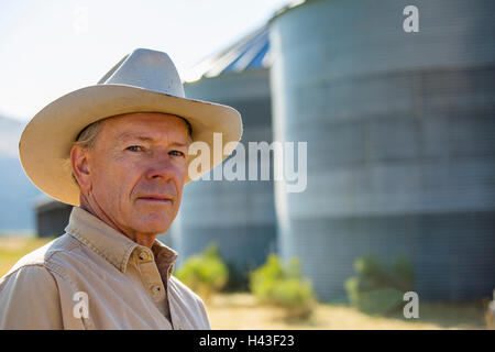 Grave agricoltore caucasica vicino a silos di stoccaggio Foto Stock