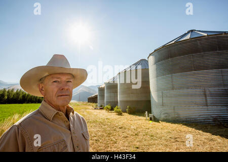 Grave agricoltore caucasica vicino a silos di stoccaggio Foto Stock