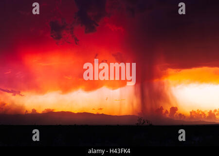 Rosso infuocato monsone tempesta al tramonto Foto Stock