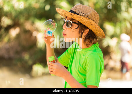 Ragazzo soffiando bolle di sapone Foto Stock