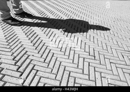 Immagine in bianco e nero del mattone marciapiede motivo con uomo in piedi al di fuori della Cooper Hewitt, Smithsonian Museo del Design Foto Stock