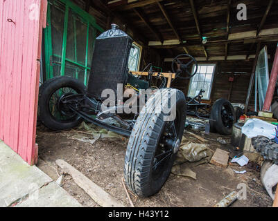 Un telaio e motore di un modello di una Ford si siede in un fienile in attesa di restauro. Foto Stock