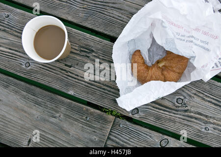 Tazza da caffè, croissant, pontile in legno, Foto Stock